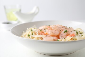 Delicious pasta with shrimps and cheese on white table, closeup