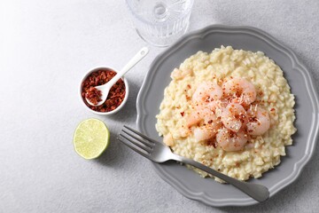 Delicious risotto with shrimps and cheese served on light grey table, top view