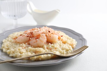 Delicious risotto with shrimps and cheese on white table, closeup