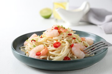 Delicious pasta with shrimps, green onion and chili pepper on white table, closeup