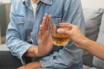 Alcoholism, depressed asian young man refuse, push out alcoholic beverage glass, drink whiskey,...