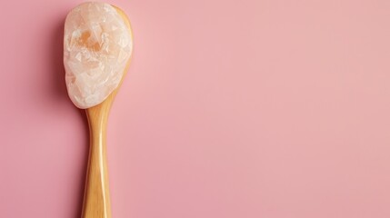 Quartz stone beauty tool for anti aging facial massage on pink backdrop with space for text