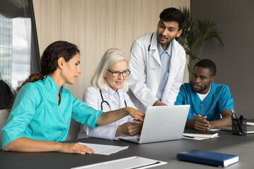 Middle-aged and millennial internists professionals using laptop, review diagnosis, check-up...