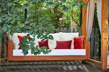 veranda with garden swing is decorated with fall decor and chrysanthemums