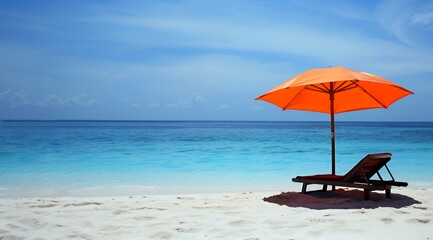 A lounge chair and orange umbrella on a white sand beach with clear blue water and a blue sky.