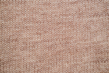 texture of knitted woolen fabric in light brown color