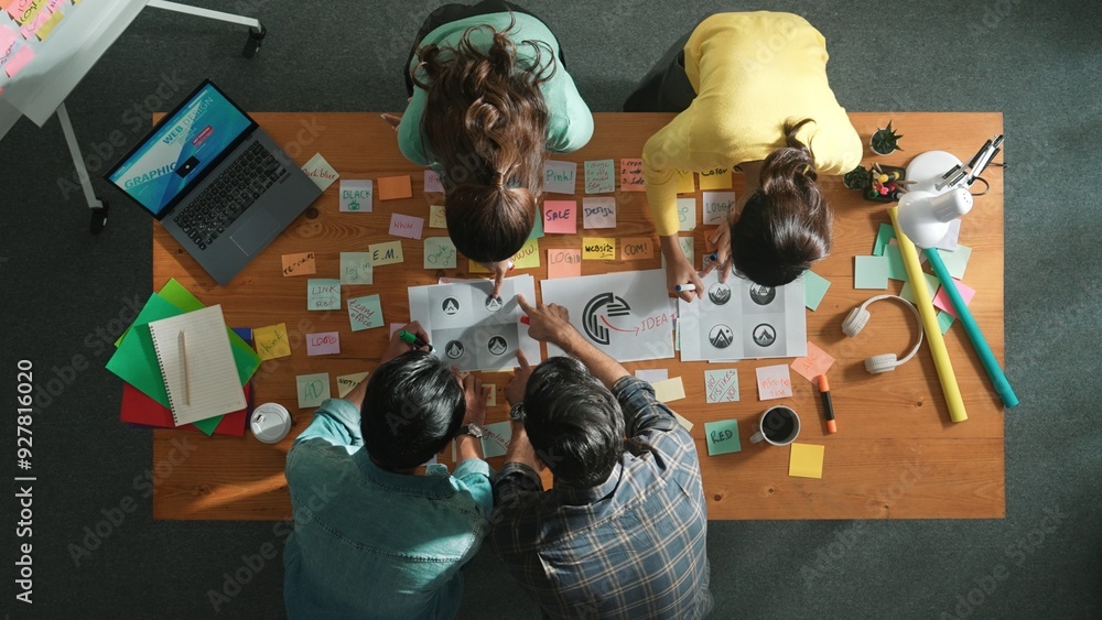 Aufkleber top down aerial view of skilled designer hold logo while discuss with team. aerial business group wo