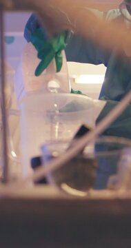 Drugs, gas mask or person pour chemical in lab for cooking meth, fentanyl or heroin. Crime, liquid or chemist with canister for manufacturing illegal substance, production or preparation of narcotics