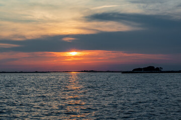 Obraz premium Fiery Sunset on the Sea, View from Grado Lighthouse, Italy: Red Orange Colors in the Sky.