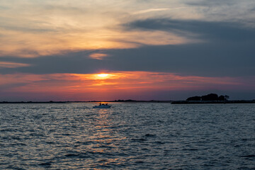 Fiery Sunset on the Sea with Distant Boat, View from Grado Lighthouse, Italy: Red Orange Colors in the Sky.