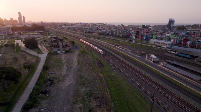 Tren llegando a la estaci&oacute;n al atardecer. Hora Magica en la ciudad. Vista de Dron. Tren. Ferrocarril. Ferrioviario. Buenos Aires. Retiro. Viaje en tren. Footage de Viaje.