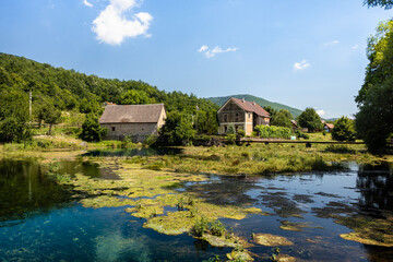 Obraz premium Wonderful Majerovo Vrilo, old mill houses made from wood and stone in the village of Sinac, Croatia, built around Gacka river source