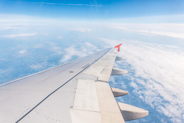 View from the airplane window at a beautiful cloudy sky and the airplane wing