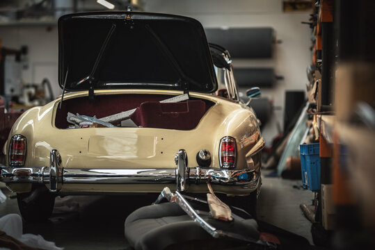 Classic cars being restored in a vintage vehicle garage workshop