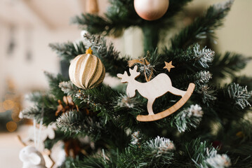 Christmas tree with a wooden deer ornament hanging from it