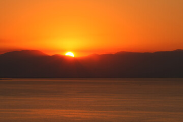 Fototapeta premium sunset or sunrise over the sea behind the mountain