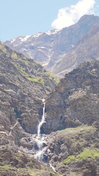 Vertical shot of waterfall in the Himalayan mountain ranges as seen from Tandi village in Pattan valley at Lahaul and Spiti district, Himachal Pradesh, India. Waterfall due to melting of glacier.