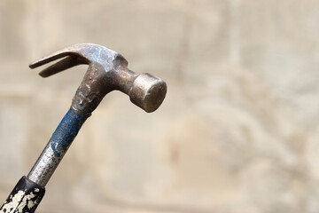 Claw hammer on a blurred background. Hammer close-up. Hand tools for repair and construction. Close-up of a hammer with a forked tail. Metal old hand hammer for carpentry and repair work