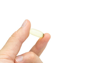 Male hand holding omega 3 soft gel capsule isolated on white background