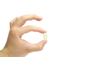 Male hand holding omega 3 soft gel capsule isolated on white background