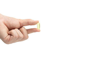 Male hand holding omega 3 soft gel capsule isolated on white background
