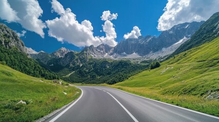 Naklejka premium Asphalt Road Leading Through Majestic Mountains