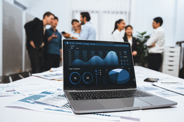 Analytic database by BI Fintech dashboard displayed on laptop for analyzed financial data on blur background with business people analyzing for insights power into business marketing planning.Prudent