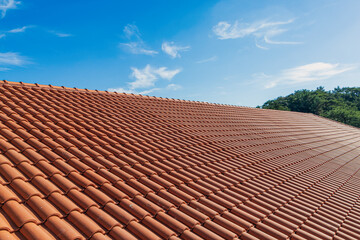 Clay tile house roof. Orange clay tile roof close-up with blue sky in the background