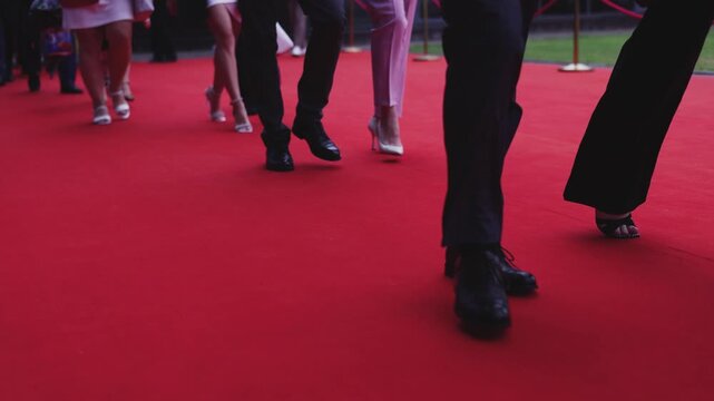 Red carpet with ropes and golden barriers on a luxury party entrance, cinema premiere film festival event award gala ceremony, wealthy rich guests arriving, outdoor decoration elements, summer day