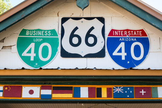 Historic route 66 and I 40 road signs on a exterior white wall.