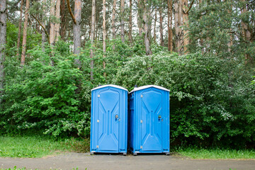 Eco-friendly bio toilet in nature. WC near the forest - photo. Women's and men's blue toilet at the festival 