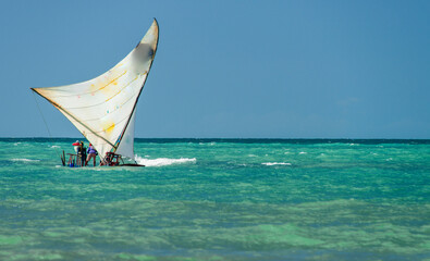 Jangada, or raft, a rustic wooden boat with a sail, typically used for fishing and recently for...