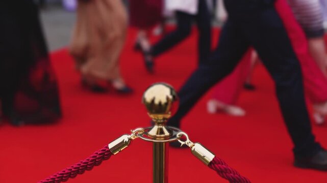 Red carpet with ropes and golden barriers on a luxury party entrance, cinema premiere film festival event award gala ceremony, wealthy rich guests arriving, outdoor decoration elements, summer day