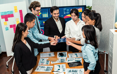 Multiethnic business people holding jigsaw pieces and merge them together as effective solution...