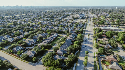 Fototapeta premium High density subdivision row of suburban houses along Coit Road with downtown Plano Texas in background, upscale homes with swimming pool in Wentworth Estates, River Bend neighborhood, aerial