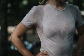 Naklejka premium A close-up image of a person wearing a sweaty t-shirt, likely after an intense outdoor workout or exercise session.