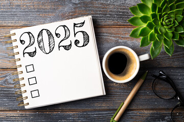 New year resolutions 2025 on desk. 2025 resolutions list with notebook, coffee cup on table. Goals, resolutions, plan, action, checklist concept. New Year 2025 template, copy space