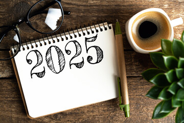 New year resolutions 2025 on desk. 2025 goals list with notebook, coffee cup, plant on wooden...
