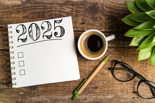 New year resolutions 2025 on desk. 2025 goals list with notebook, coffee cup, plant on wooden table. Resolutions, plan, goals, action, checklist, idea concept. New Year 2025 template, copy space