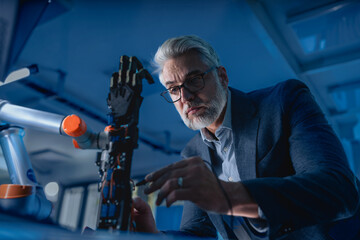 Robotics engineer adjusting, calibring robotic prosthetic hand. Concept of modern technology in medicine. Robotic prosthetics, biomechatronics and neuroscience.