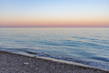 The ocean is calm and the sky is a beautiful shade of pink