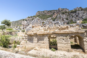 A stone building with a small window and a tree in front of it