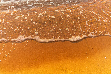 Soft wave of the sea on the sandy beach.