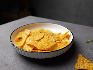 Savory salted corn chips on a plate with a plain background