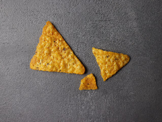 One corn chip or tortilla chip is triangular in shape on a white background.