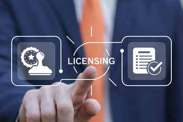 Business man using virtual touch interface presses word: LICENSING. License agreement business...