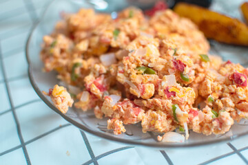 Plato de huevos revueltos con jitomate rojo y cebolla 