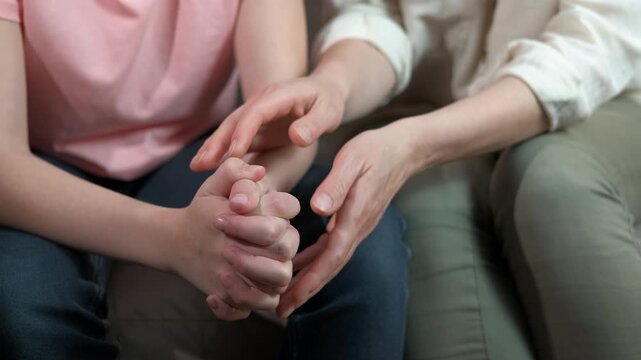 Mother hold child hands to apology. A woman takes teen hands and try to support her during depression time.