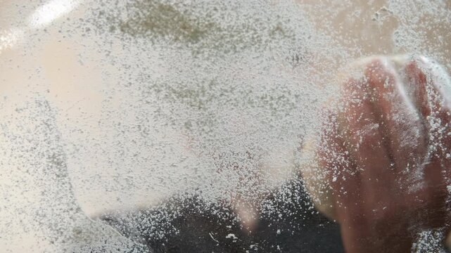 Lady cook knead smooth dough. A view of lady sift the flour on the table to make the tasty dough for pastry