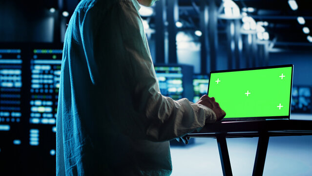 Asian employee using isolated screen laptop to implement artificial intelligence parallel processing. Professional works on chroma key device enabling AI systems to do machine learning inference